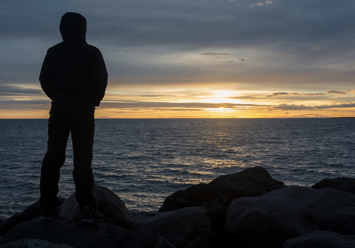 un homme debout regarde un coucher de soleil DOMINIK BELICA/SHUTTERSTOCK.COM
