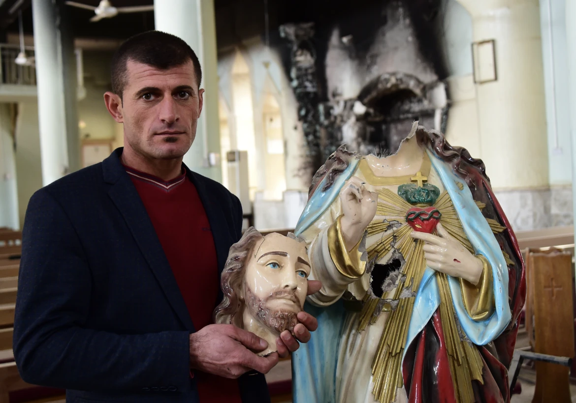 Un chrétien d’Irak montre une statue du Sacré-Cœur décapitée par Daech.